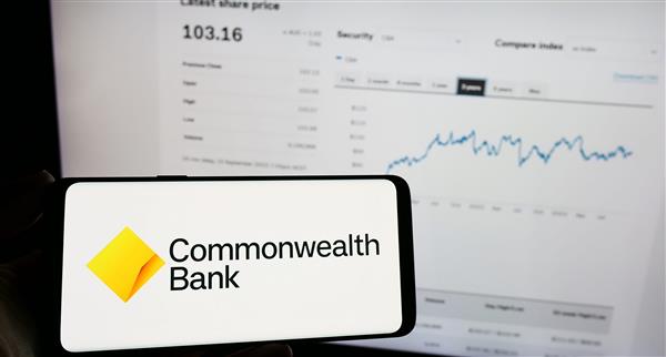 Image of someone holding a phone with a CBA app on it.