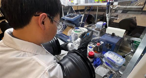 A scientist working at a lab desk.